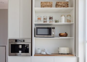 Appliance Garage in a modern kitchen with a microwave, a toaster and cutlery.