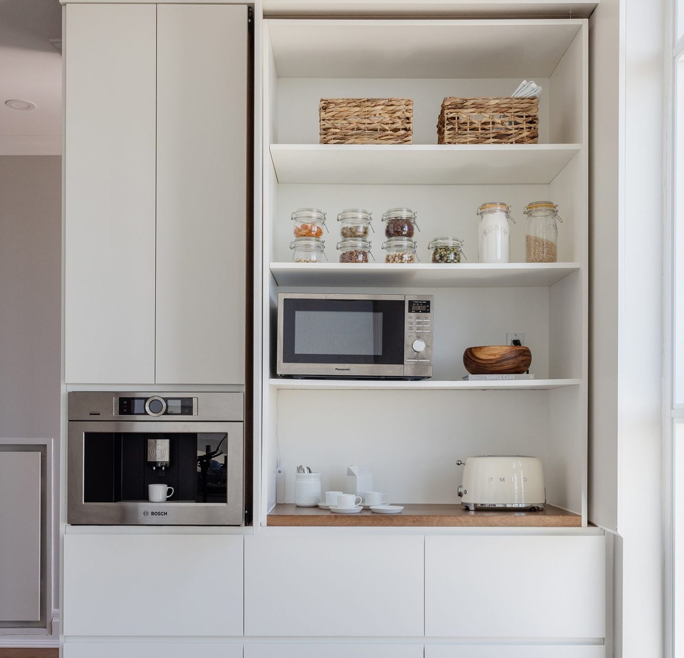 Appliance Garage in a modern kitchen with a microwave, a toaster and cutlery.